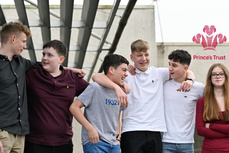 Group of young people with arms round each other
