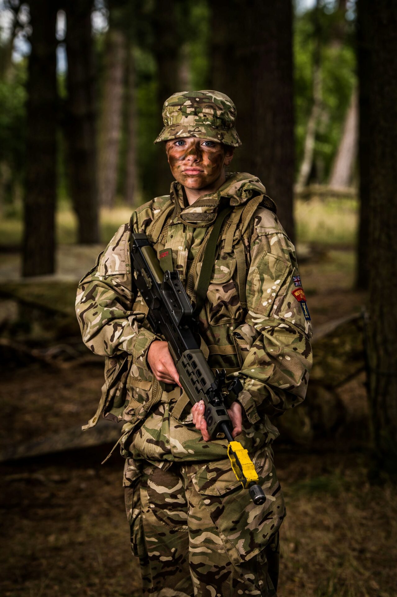 Rhonwen Paterson, an Army Cadet Force Sergeant standing in camo gear with rifle in her hands