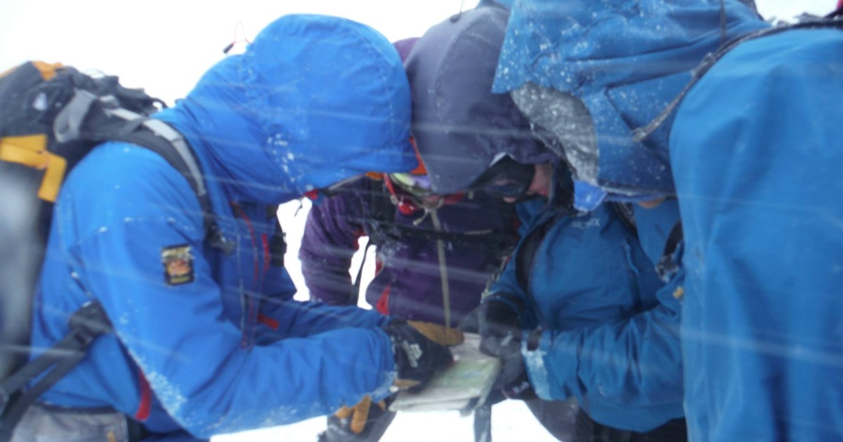 Hillwalkers looking at map in wintery weather conditions