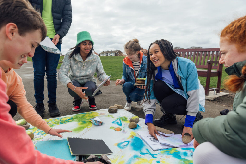 A group of teens taking part in a learning activity outdoors to highlight the credit rating funding that's available