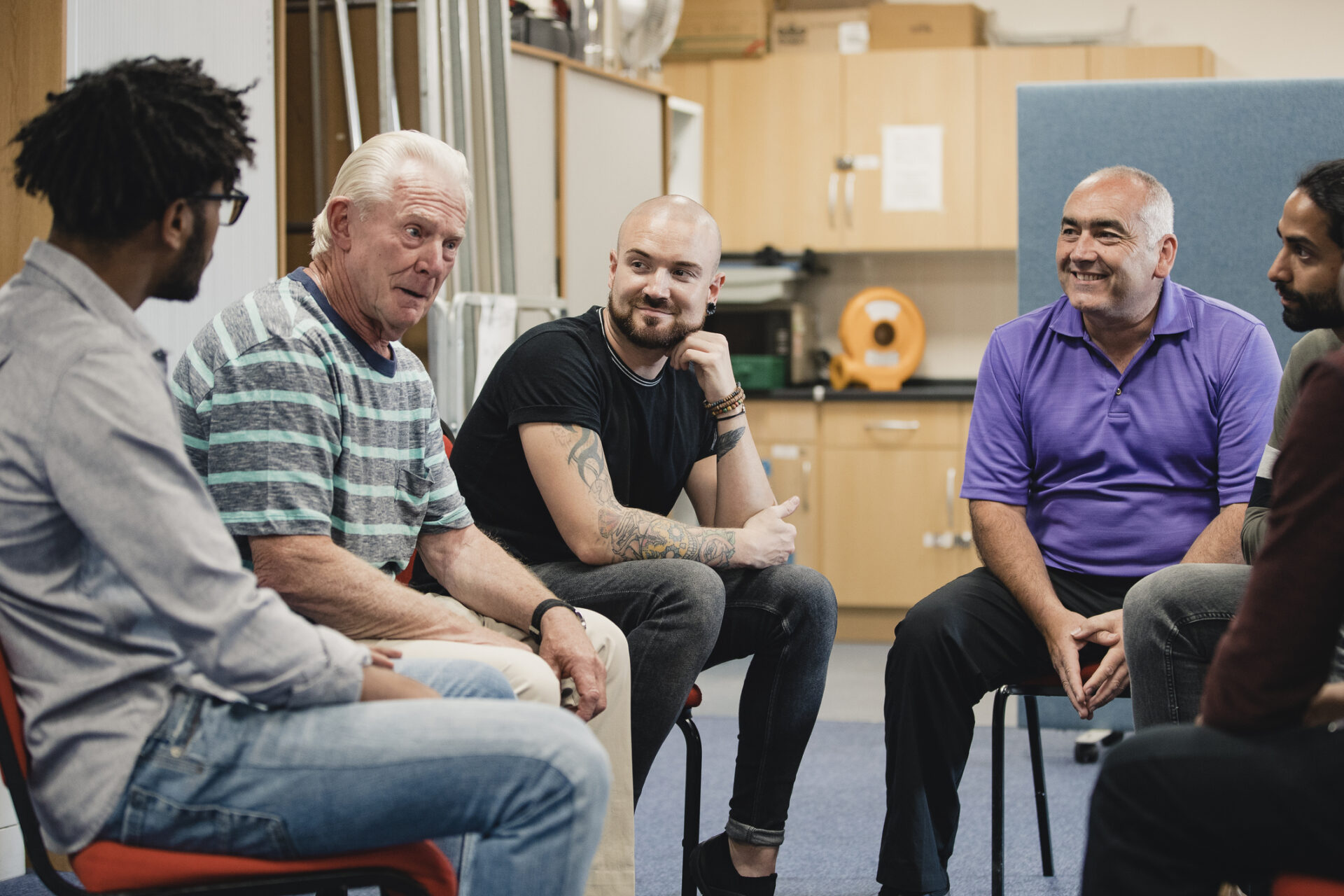 Generic image of group therapy with men sitting in a circle talking